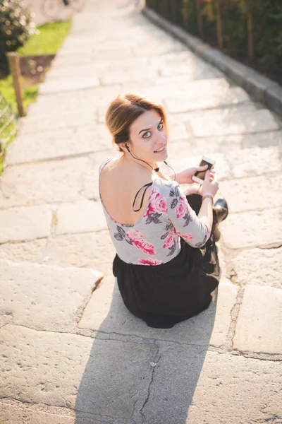 Mujer rubia escuchando música al aire libre — Foto de Stock