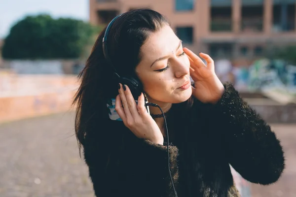 Giovane ragazza nel parco con le cuffie — Foto Stock