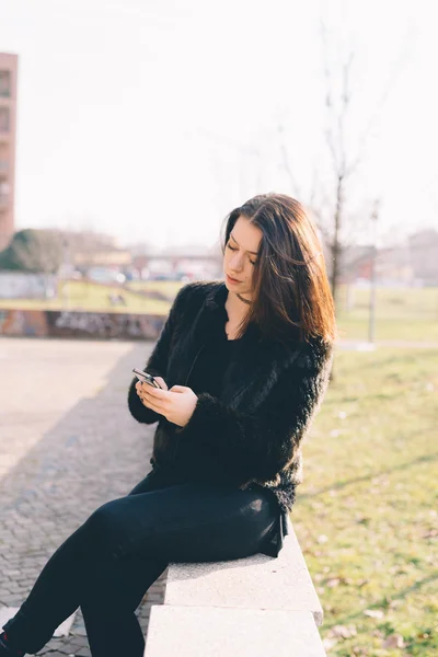 Mujer hermosa joven usando teléfono inteligente —  Fotos de Stock