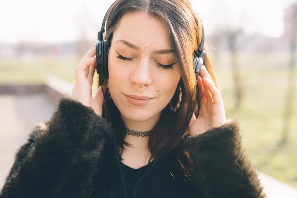 Ung flicka i parken med hörlurar — Stockfoto