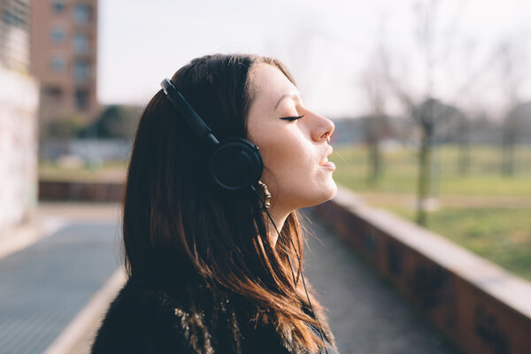 young girl in park with headphones