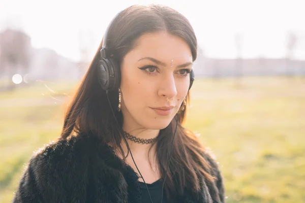Chica joven en el parque con auriculares —  Fotos de Stock