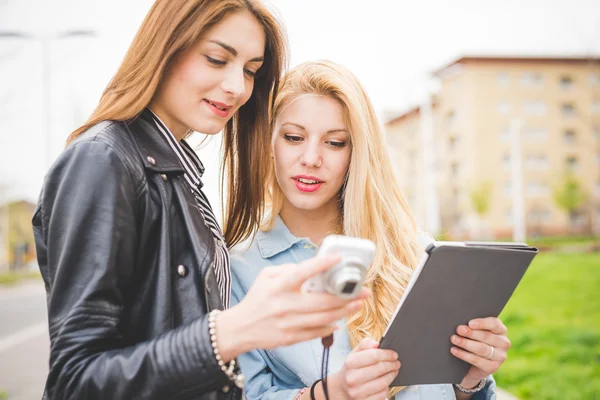 Two girls in city with devices — Stock Photo, Image