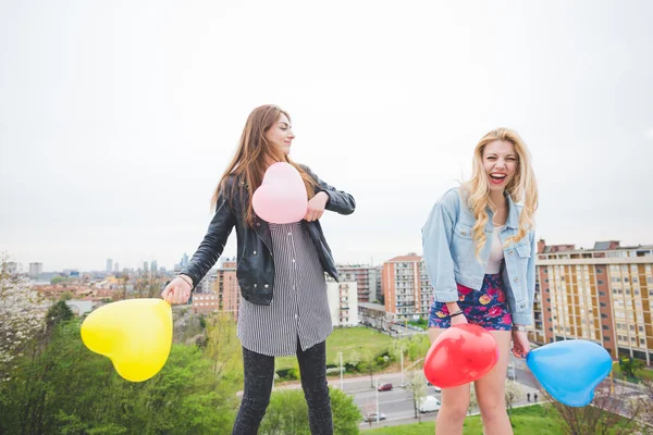 Two beautiful girls playing with balloons — Stock Photo, Image