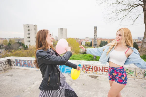 Two beautiful girls playing with balloons — Stock Photo, Image
