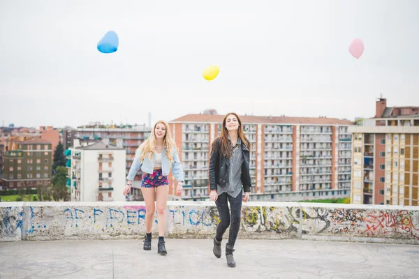 Zwei schöne Mädchen spielen mit Luftballons — Stockfoto