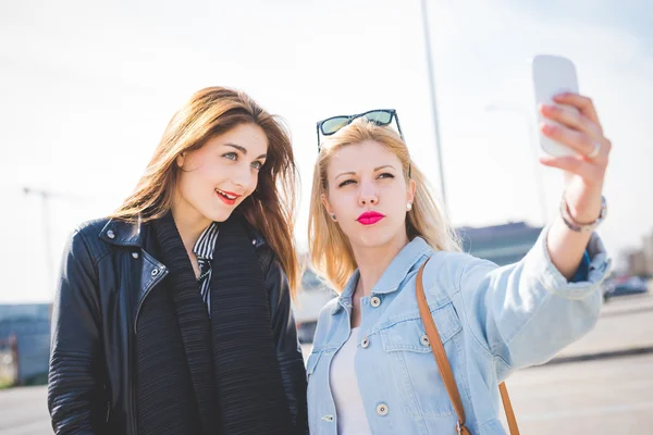 Två tjejer tar selfie i city — Stockfoto