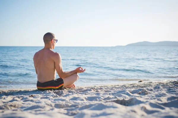 Uomo che fa yoga sulla spiaggia — Foto Stock