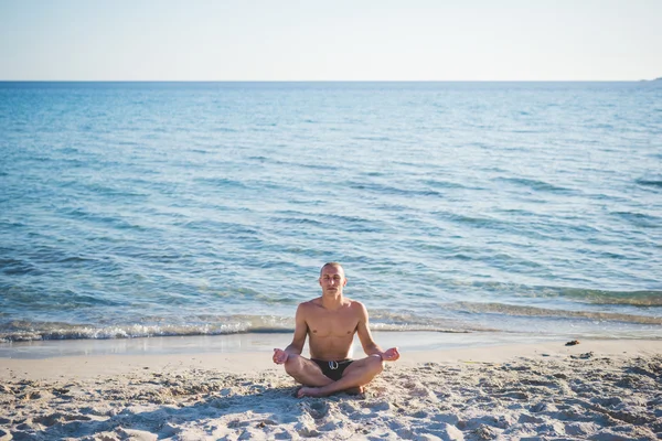 Uomo che fa yoga sulla spiaggia — Foto Stock