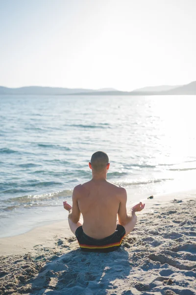 Uomo che fa yoga sulla spiaggia — Foto Stock