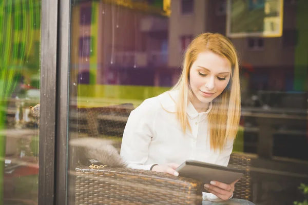 Ung kvinna i restaurang med tablett — Stockfoto