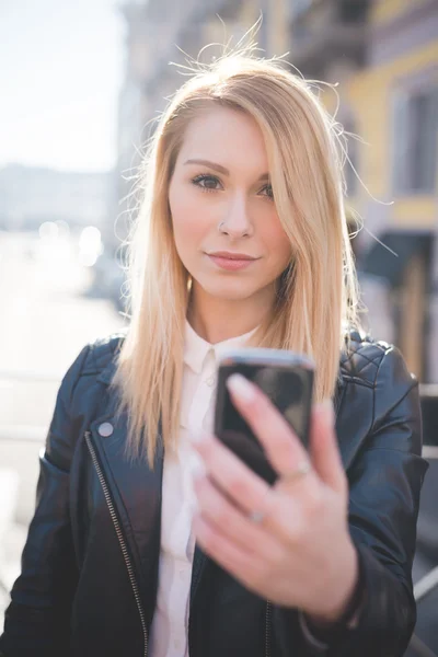 Belle femme en ville avec smartphone — Photo