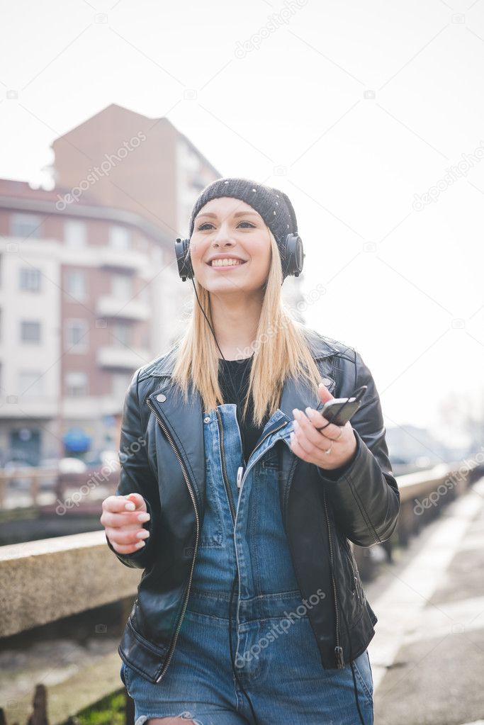 beautiful woman with headphones in city