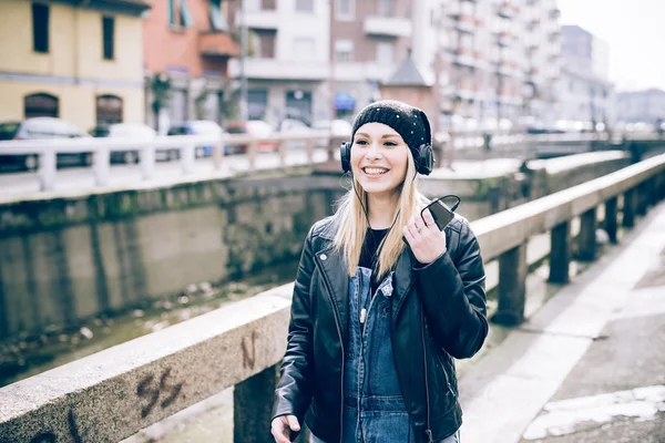 Mooie vrouw met hoofdtelefoon in stad — Stockfoto