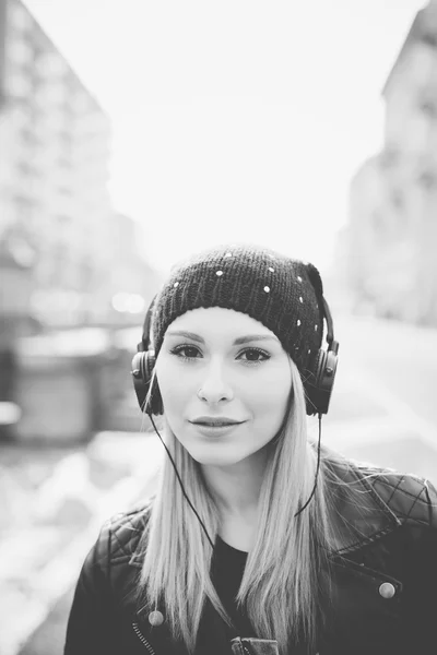 Belle femme avec écouteurs en ville — Photo