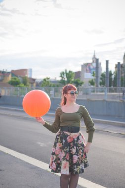 Balon ile oynayan genç yakışıklı Kızıl saçlı kadın