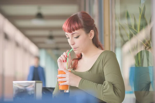 Ung vacker rödhårig kvinna dricka saft — Stockfoto