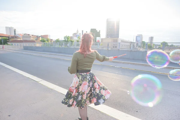 Jonge knappe roodharige vrouw speelt met bubble — Stockfoto