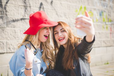 Young beautiful friends girls taking selfie