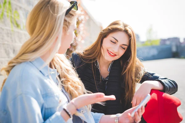 Deux jeunes femmes amies utilisant un smartphone — Photo