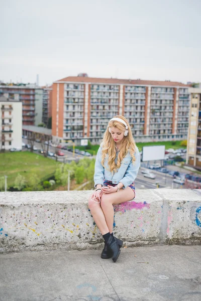 Ung snygg blond tjej lyssnar musik — Stockfoto
