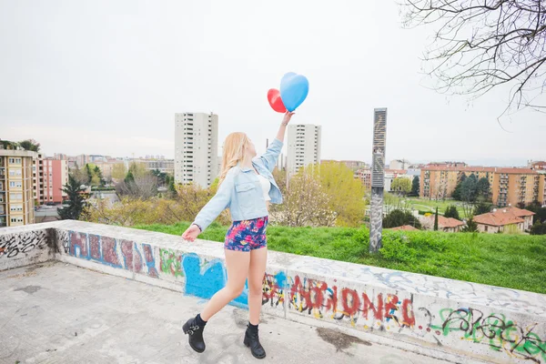 Jovem linda menina loira jogando balões — Fotografia de Stock