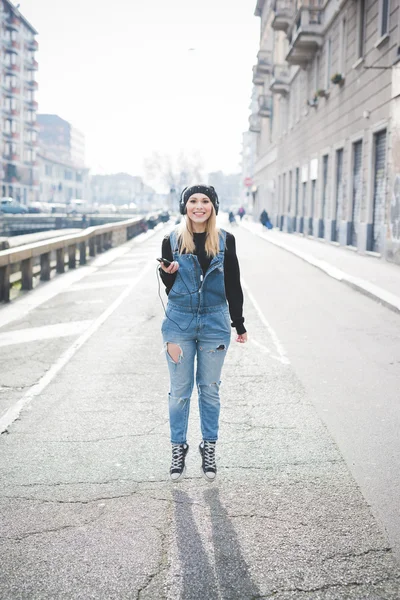 Mujer rubia con auriculares escuchando música — Foto de Stock