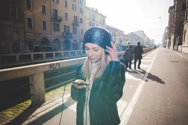 Mujer rubia con auriculares escuchando música — Foto de Stock