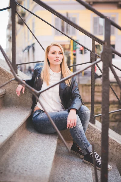Jonge mooie blonde vrouw in stad — Stockfoto