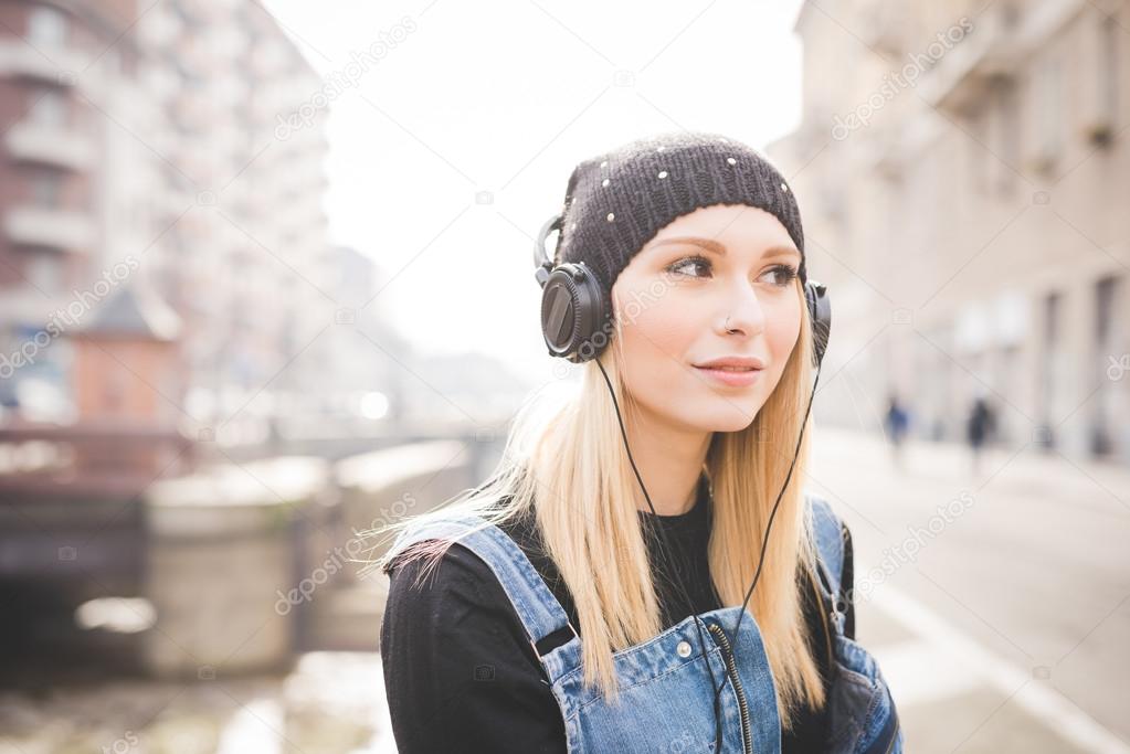 Blonde woman with headphones listening to music