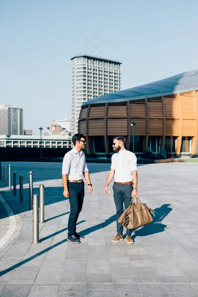 Два современных бизнесмена позируют в городе — стоковое фото