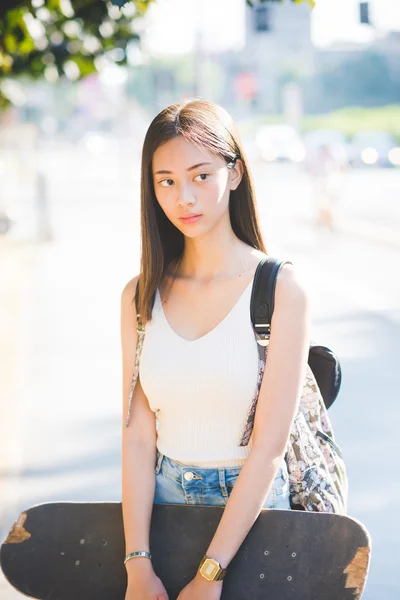 Asiático mulher segurando um skate — Fotografia de Stock