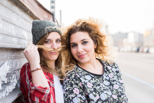 women leaning on a wall