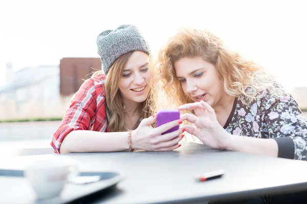 Ženy sedí na baru, pomocí chytrého telefonu — Stock fotografie