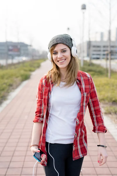 Girl walking and dancing through the street — Stock Photo, Image