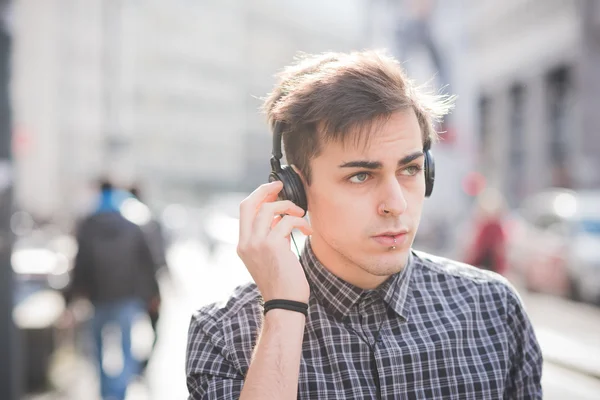 Hombre en la ciudad escuchando música — Foto de Stock