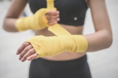 woman wrapping her hands with a band