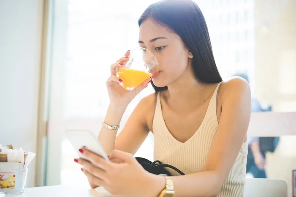 Femme assise dans un bar, buvant un jus — Photo