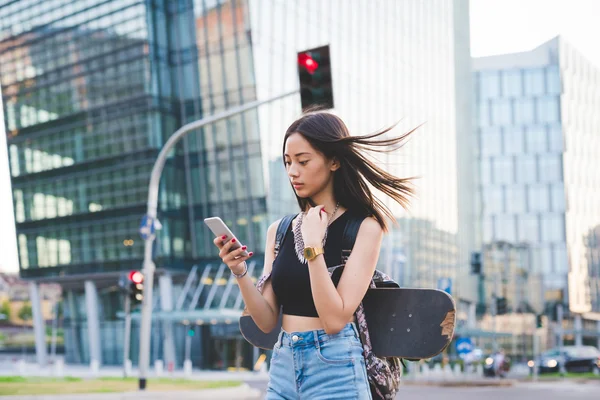 Woman skater walking in the city — Stockfoto