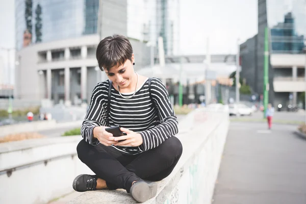 Femme assise sur un petit mur — Photo