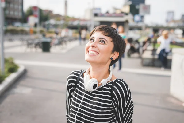 Femme avec casque autour du cou — Photo