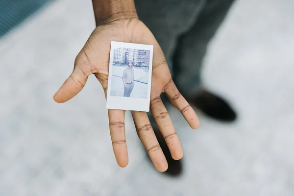 Man showing a polaroid of himself