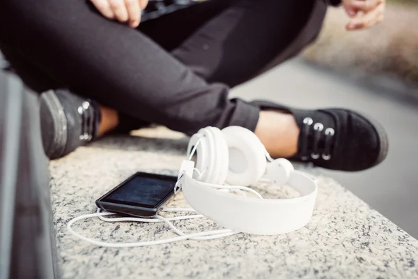 Smartphone and headphones leaning on a wall — Stock Photo, Image