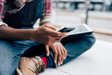 Bir akıllı telefon kullanan Afro siyah adam