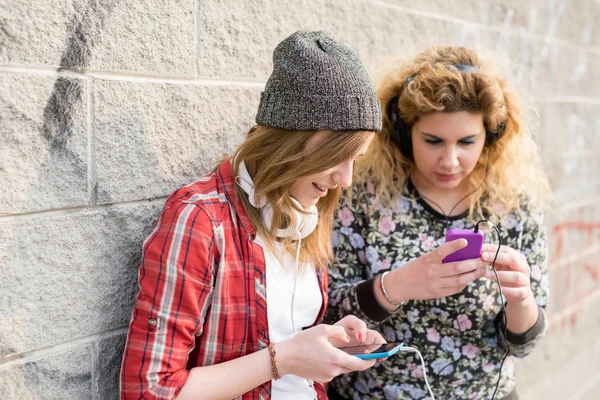 Femmes appuyées contre le mur, écoutant de la musique — Photo