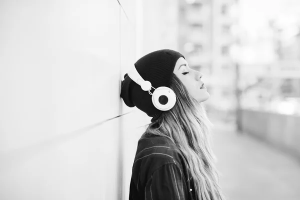 Duvara karşı müzik dinleme eğilerek kadın — Stok fotoğraf