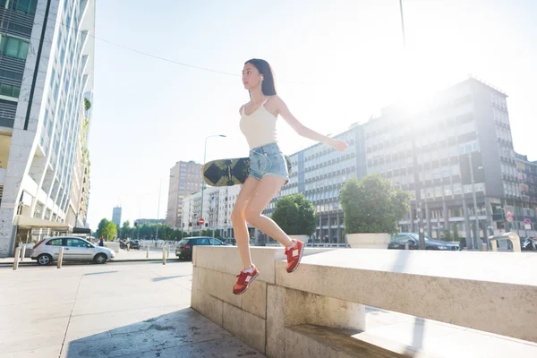 Woman skater jumping from a wall — Stok fotoğraf