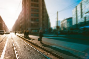 Şehirde bir kaldırımda tramvay için bekleyenler