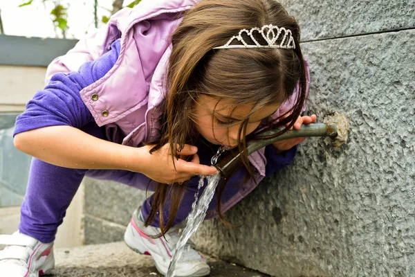 Enfant qui boit de l'eau d'une fontaine — Photo