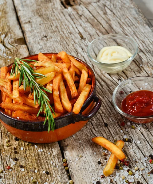 French fries in a bowl on a rustic wooden floor — Stock Photo, Image